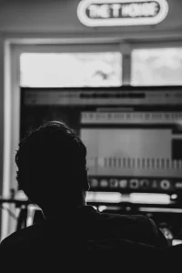 THS_RADDAR_PHOTOS_15 A silhouette of a man working on a computer screen with a music production interface.