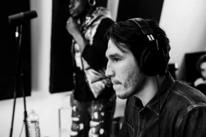 THS_RADDAR_PHOTOS_22 A focused young man wearing headphones, listening intently in a recording studio.